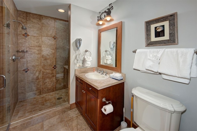 bathroom featuring toilet, walk in shower, and vanity