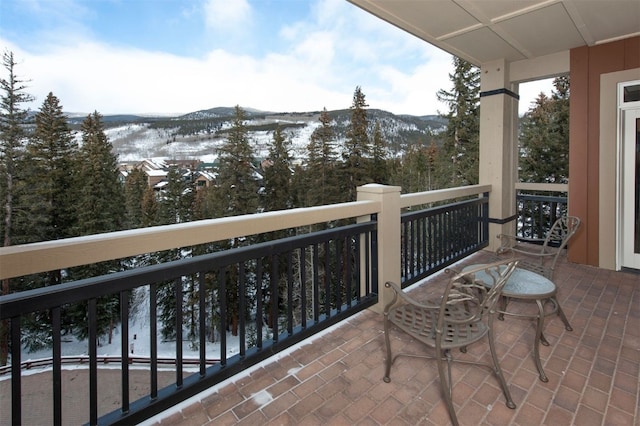 snow covered back of property with a mountain view