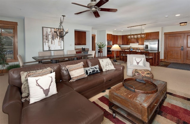 living room with ceiling fan with notable chandelier and light carpet