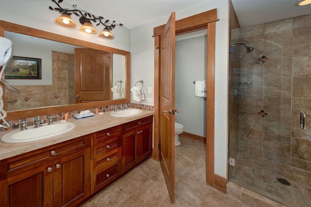 bathroom with a shower with shower door, backsplash, vanity, and toilet