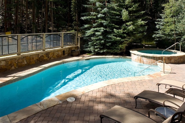 view of swimming pool with an in ground hot tub