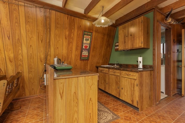 kitchen with beam ceiling and wood walls