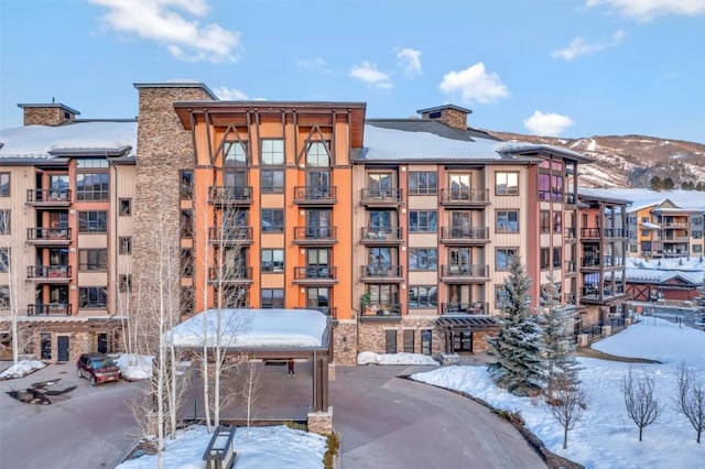 snow covered building featuring a mountain view