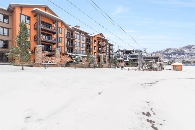 snow covered building featuring a mountain view