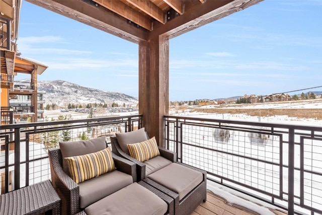 snow covered back of property with a mountain view