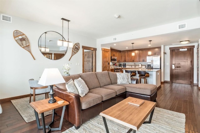 living room with baseboards, visible vents, and dark wood-style flooring