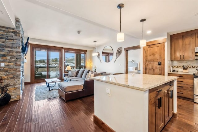 kitchen featuring dark wood-style floors, pendant lighting, decorative backsplash, open floor plan, and light stone countertops