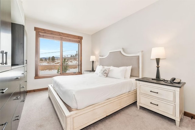 bedroom with light carpet and baseboards