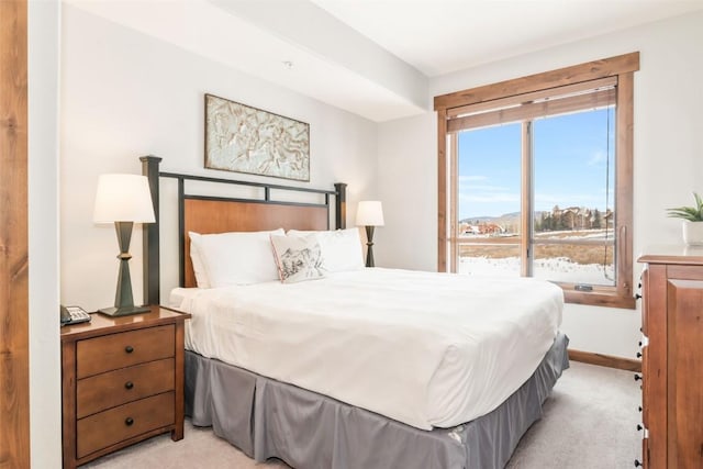 bedroom featuring light colored carpet and baseboards