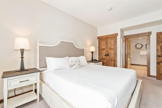 bedroom with baseboards and light colored carpet