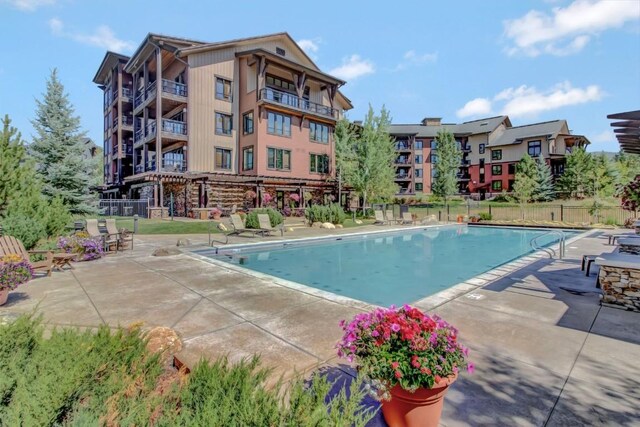 community pool with fence and a patio