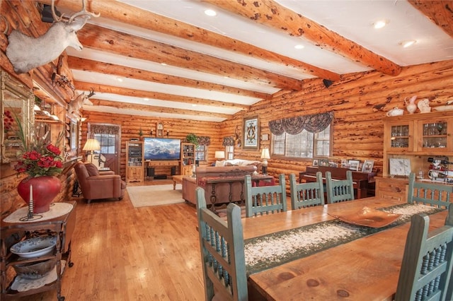 dining space featuring hardwood / wood-style floors, beamed ceiling, recessed lighting, and log walls