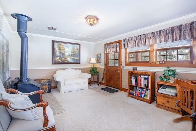 living area with crown molding, a wood stove, visible vents, and carpet floors