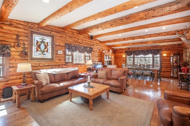 living room featuring beamed ceiling, wood finished floors, and a healthy amount of sunlight