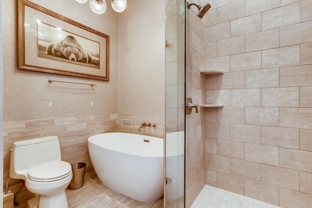 bathroom featuring independent shower and bath, toilet, and tile walls