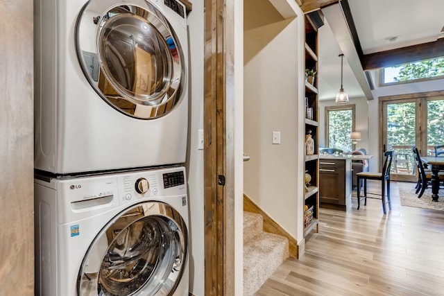 washroom featuring stacked washer and dryer and light wood-type flooring