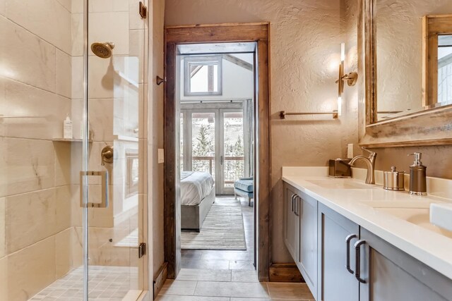 bathroom featuring a shower with shower door and vanity