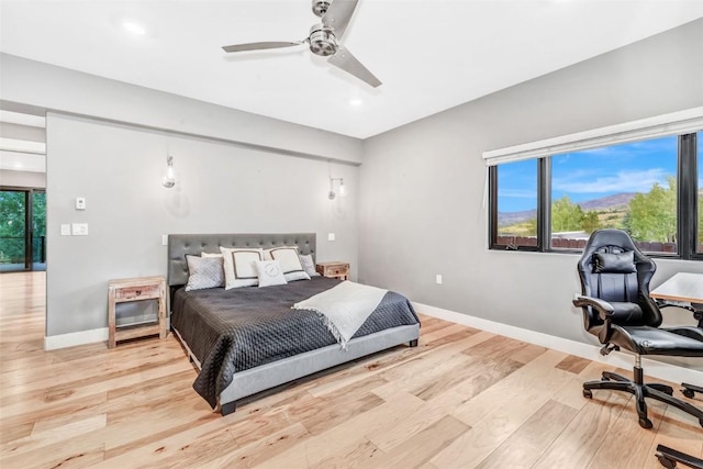 bedroom with multiple windows, ceiling fan, and light hardwood / wood-style floors