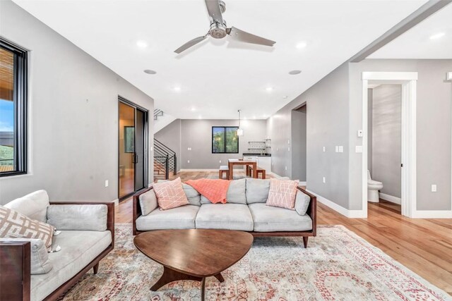 living room with ceiling fan and light wood-type flooring