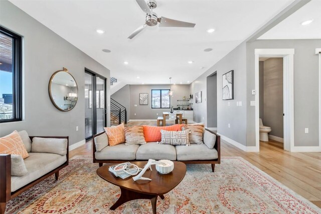 kitchen with appliances with stainless steel finishes, backsplash, sink, decorative light fixtures, and light hardwood / wood-style floors