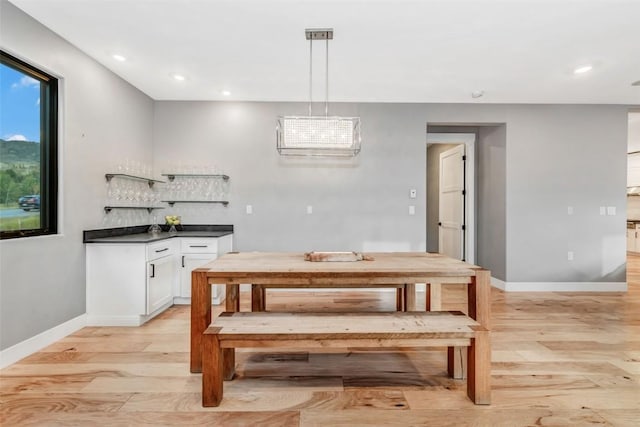 dining area featuring light hardwood / wood-style floors and bar