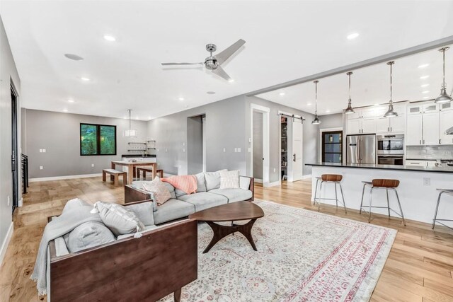 living room featuring ceiling fan and light hardwood / wood-style floors