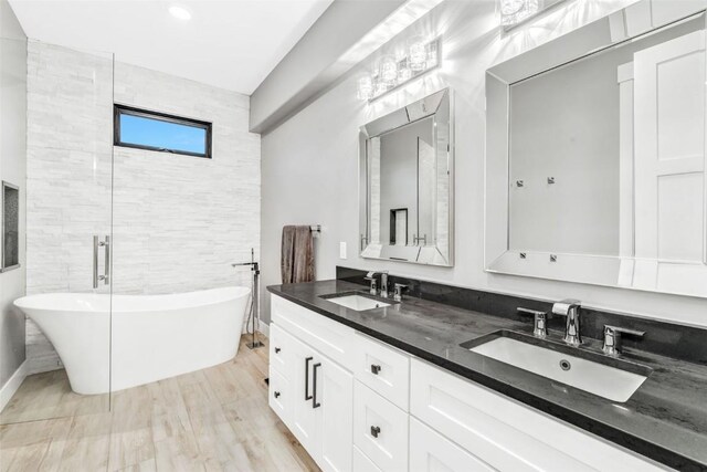 bathroom with wood-type flooring, vanity, and a bathing tub