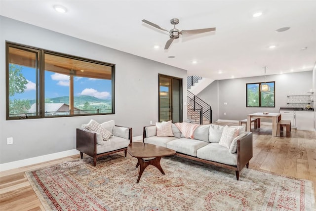 living room with ceiling fan and light hardwood / wood-style floors