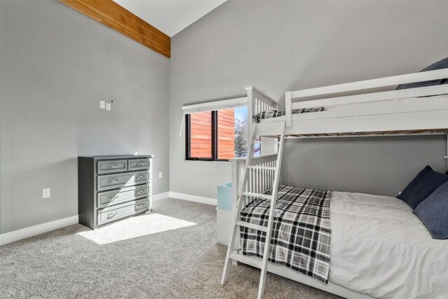 carpeted bedroom with beam ceiling and ceiling fan