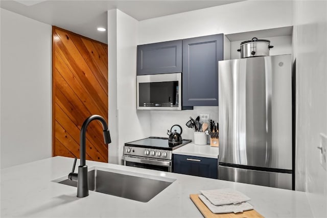 kitchen with light stone counters, appliances with stainless steel finishes, and sink