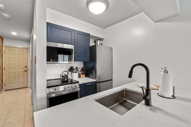 kitchen with blue cabinets, sink, stainless steel appliances, and light tile patterned flooring