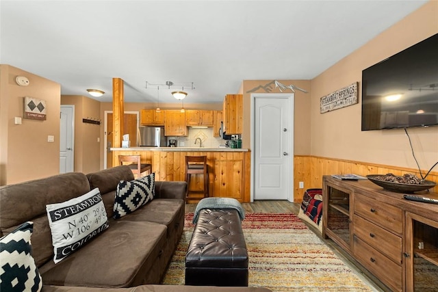 living room with light hardwood / wood-style floors and sink