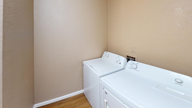 clothes washing area with separate washer and dryer and hardwood / wood-style floors