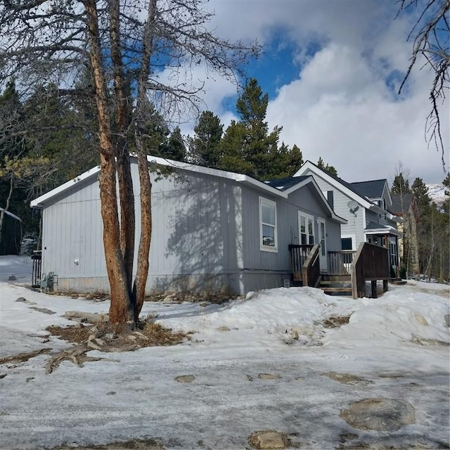 snow covered property with a wooden deck