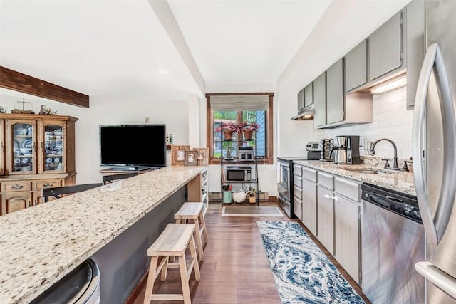 kitchen with sink, dark wood-type flooring, gray cabinetry, stainless steel appliances, and decorative backsplash