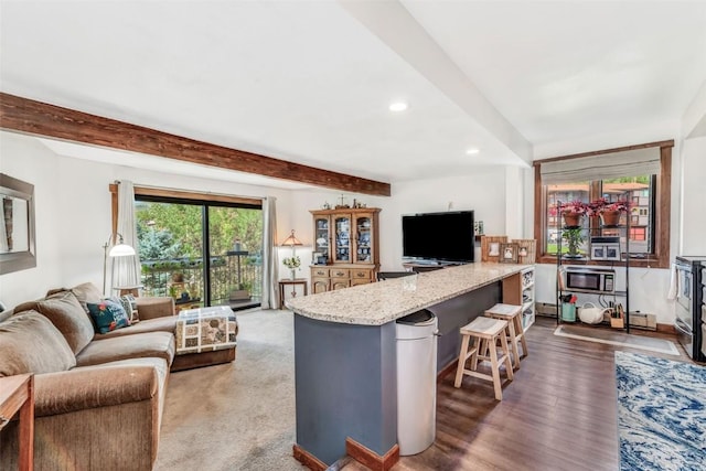 living room featuring beamed ceiling and dark hardwood / wood-style flooring