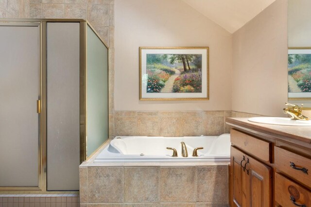 bathroom with vanity, vaulted ceiling, and shower with separate bathtub