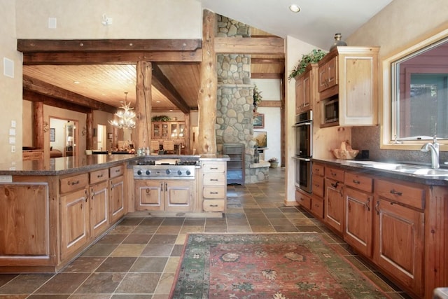 kitchen featuring kitchen peninsula, appliances with stainless steel finishes, sink, beamed ceiling, and a chandelier