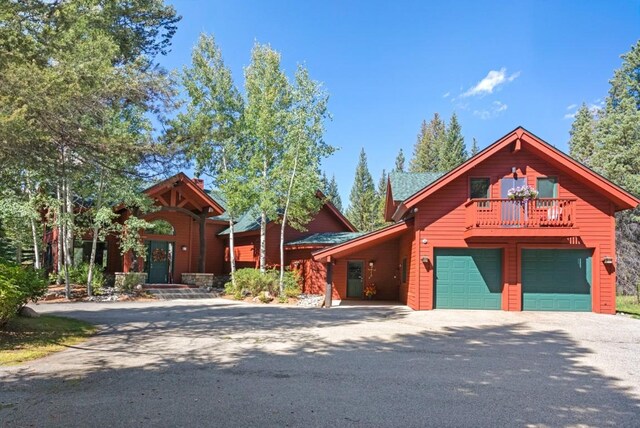 log home with a garage and a balcony