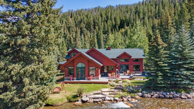 rear view of property featuring a yard and a wooden deck