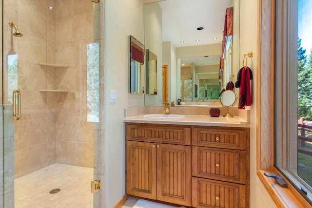 bathroom featuring a wealth of natural light, a shower with door, and vanity