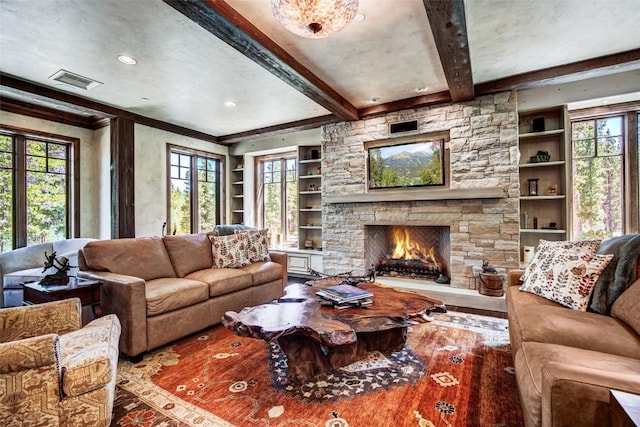 living room with a fireplace, beam ceiling, built in features, and ornamental molding