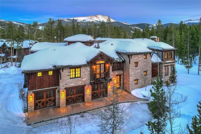 snow covered rear of property featuring a mountain view