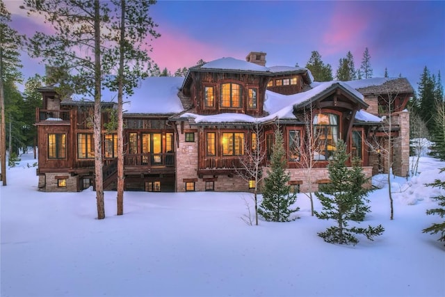 view of snow covered back of property