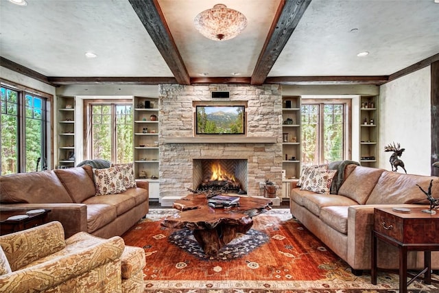 living room featuring beamed ceiling, built in features, and a fireplace