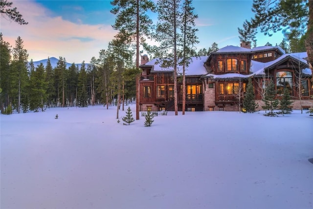 view of snow covered back of property