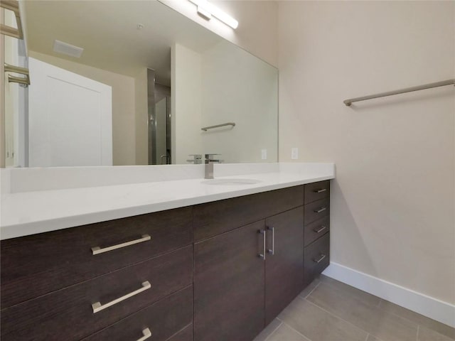 bathroom with vanity, a shower with door, and tile patterned flooring