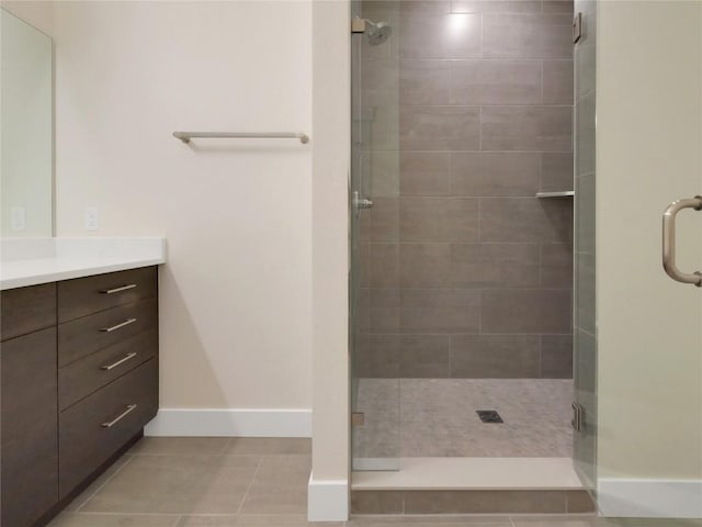 bathroom featuring vanity, tile patterned flooring, and a shower with door