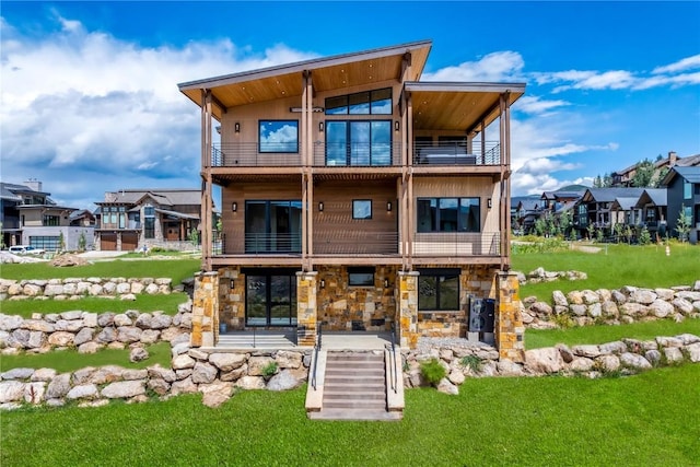 rear view of property with a balcony, a patio area, and a lawn