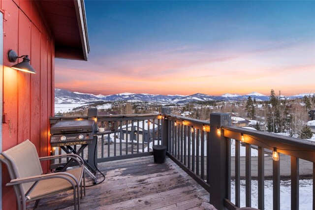 snow covered deck featuring grilling area and a mountain view